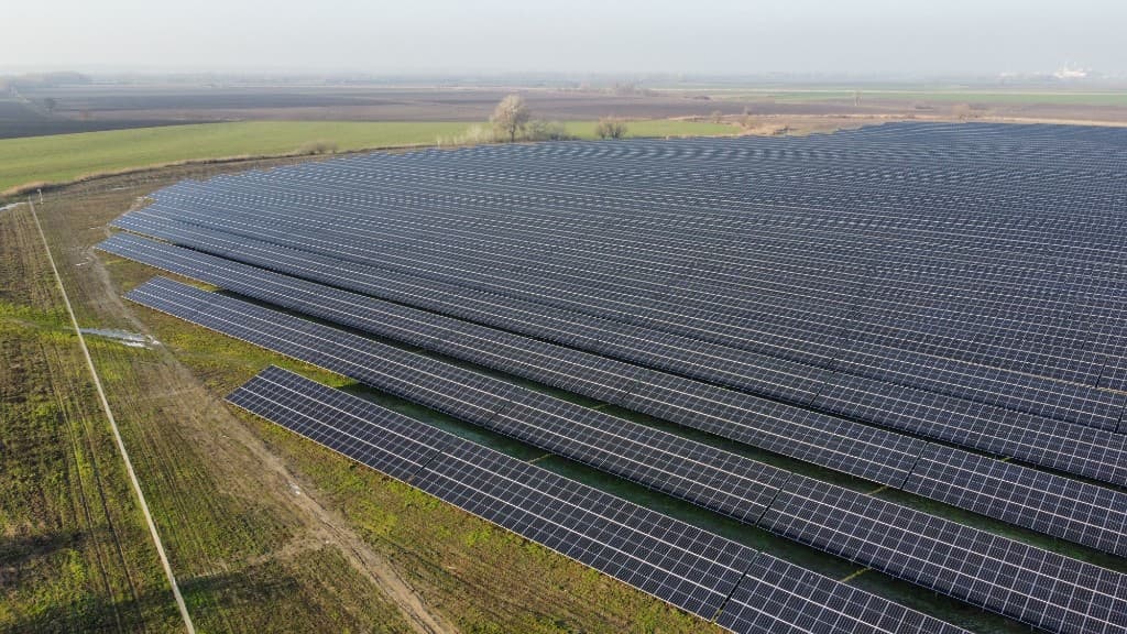 Aerial view of a ground-mounted solar power plant on agricultural land, typical of a PM-KUSUM Component A EPC project